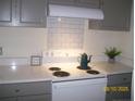 Bright kitchen featuring white appliances and gray cabinets with tile backsplash at 162 Deer Vw, Sanford, NC 27332