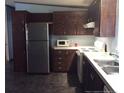 Functional kitchen with stainless steel appliances and dark wood cabinets, perfect for cooking enthusiasts at 165 Brent Wood, Sanford, NC 27332