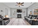 Spacious living room with a fireplace, large windows, neutral paint, and plush furniture at 28 Coswell Ct, Cameron, NC 28326
