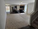 Open floor plan with carpeted living room and kitchen with island and stainless steel appliances at 280 Hallow Oak Dr, Spring Lake, NC 28390
