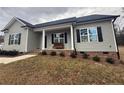 Welcoming front porch with brick steps, seating, and gray siding at 4271 Mcdougald Rd, Lillington, NC 27546