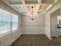Bright dining room featuring coffered ceilings, a chandelier, and large windows, with wood-look floors at 46 Pikewood Ct, Lillington, NC 27546