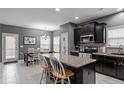 Modern kitchen featuring dark cabinets, granite countertops, and stainless steel appliances at 63 Slate Dr, Spring Lake, NC 28390