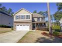 Two-story home featuring stone accents, a two-car garage, covered porch, and manicured landscaping at 207 Heather Brook Cir, Spring Lake, NC 28390