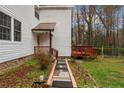 View of the home with a small deck, pathway, and green lawn, ideal for outdoor enjoyment and entertaining at 441 Windy Bch, Sanford, NC 27332