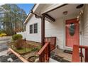 Close-up of the home's entrance with a pink door, a small porch, and manicured landscaping details at 441 Windy Bch, Sanford, NC 27332