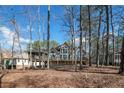 Exterior view of the back of the home featuring a deck and tree-lined yard at 6090 Dunes Dr, Sanford, NC 27332