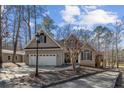 Traditional home with an attached two-car garage, enhanced by mature trees and natural sunlight at 6090 Dunes Dr, Sanford, NC 27332