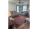 Comfortable living room featuring two sofas, a ceiling fan, natural light, and a decorative area rug at 124 Brookfield Cir, Sanford, NC 27330