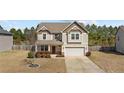 Charming two-story home featuring a well-manicured lawn and an attached two-car garage at 251 Crane Way, Bunnlevel, NC 28323