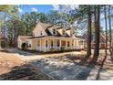 Side view of the home showcasing the expansive wraparound porch and long driveway with ample parking at 281 Pineridge Cv, Sanford, NC 27332