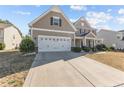 View of home featuring a two-car garage, neutral siding, and a well-maintained driveway at 30 Yaupon Cir, Spring Lake, NC 28390