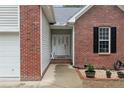 Home entrance featuring decorative front door and brick and siding details at 33 Woodbury Ln, Sanford, NC 27332