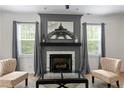 Living room showcasing fireplace with white marble, gray walls, modern art, and natural light at 201 Persimmon Tree Dr, Cameron, NC 28326