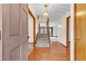 Inviting foyer features hardwood floors, a staircase, and an elegant chandelier, creating a warm welcome at 28 Ravens Wood Cir, Sanford, NC 27332