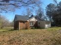 View of the back of the brick home, showcasing the backyard and detached garage at 33 Alberta Ln, Cameron, NC 28326