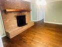 Inviting living room features a brick fireplace and hardwood floors at 33 Alberta Ln, Cameron, NC 28326