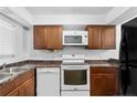 Bright kitchen with white appliances, wood cabinets, and marble countertops at 7036 Longstreet Dr # B, Raleigh, NC 27615