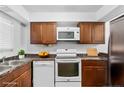 Bright kitchen with white appliances, wood cabinets, and marble countertops at 7036 Longstreet Dr # B, Raleigh, NC 27615