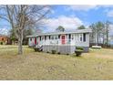 Single-story home boasts a well-maintained lawn and charming curb appeal with multiple entrances at 148 Manchester Dr, Goldston, NC 27252