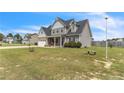 Inviting two-story home with a stone-accented garage and welcoming front porch, surrounded by a green lawn at 18 Harvest Cts, Linden, NC 28356