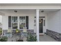 Inviting front porch with seating, stone accents, and craftsman-style front door at 268 Kensington Dr, Spring Lake, NC 28390