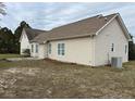 Rear view of a house with neutral siding, showcasing a large backyard with an AC unit at 41 Truman Ln, Cameron, NC 28326