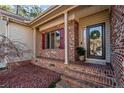 Inviting front porch with brick details, a stylish front door, and a decorative wreath at 51 Cedar Ln, Sanford, NC 27332