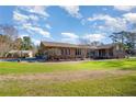 Charming single-story brick home featuring a large front lawn and multiple windows at 1010 Henley Rd, Sanford, NC 27330