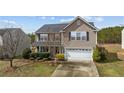 Well-maintained two-story house with a paved driveway and mature landscaping at 126 Thimbleweed Dr, Lillington, NC 27546