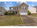 Inviting home featuring a front porch, manicured lawn, and two-car garage at 126 Thimbleweed Dr, Lillington, NC 27546