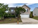 Two-story home featuring a covered porch, two-car garage, manicured shrubs, and a tidy front lawn at 126 Thimbleweed Dr, Lillington, NC 27546