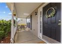 Inviting covered front porch features outdoor seating, hanging plants, and a decorative wreath on the front door at 126 Thimbleweed Dr, Lillington, NC 27546