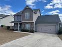 Beautiful two-story home featuring a two-car garage, manicured landscaping, and classic architectural details at 43 Battery Way, Bunnlevel, NC 28323