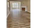 Living room with hardwood floors, a fireplace, neutral colored walls, and large windows at 261 River Falls Rd, Sanford, NC 27332