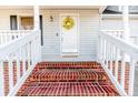 Close up of front entrance featuring decorative brick steps, white railings and a bright yellow welcome wreath at 336 Richmond Park Dr Dr, Cameron, NC 28326