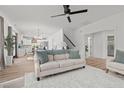 Bright living room with hardwood floors open to the kitchen and a staircase at 71 Persimmon Tree Dr, Cameron, NC 28326