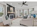 Bright living room with fireplace, neutral furniture, ceiling fan, and lots of natural light at 71 Persimmon Tree Dr, Cameron, NC 28326