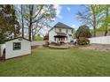A beautiful backyard with plush artificial grass, an entertainment space, and a white fence at 1300 Linden Ridge Dr, Holly Springs, NC 27540