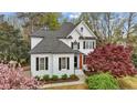 Beautiful exterior view of a two-story home showcasing well-maintained landscaping, a modern roof, and a freshly painted white facade at 1300 Linden Ridge Dr, Holly Springs, NC 27540
