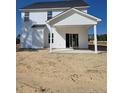 An exterior view of a home's backyard featuring a covered porch and sliding glass doors to the home at 30 Blackgum Ct, Spring Lake, NC 28390