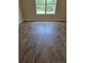 Bright bedroom showcasing wood-look floors and a large window with views of the outdoors at 52 Blackgum Ct, Spring Lake, NC 28390