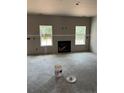 A living room with large windows, a cozy fireplace and potential for a stunning living space at 228 Dove Rd, Cameron, NC 28326
