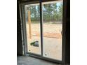 View through sliding patio door to the outdoor living space, which has abundant natural light and serene backyard views at 228 Dove Rd, Cameron, NC 28326
