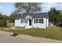 Charming single-Gathering home showcasing white painted brick and black shutters on a sunny day at 111 Spring Branch Rd, Dunn, NC 28334