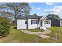 Attractive single-story home with white brick, black shutters, and a welcoming walkway to the front door at 111 Spring Branch Rd, Dunn, NC 28334