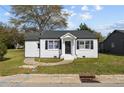 Quaint home with white painted brick, black shutters, and a well-manicured front yard at 111 Spring Branch Rd, Dunn, NC 28334