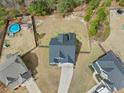 Aerial view of a home with a backyard including a pool, play set, and surrounded by mature trees at 405 Turriff Way, Cameron, NC 28326
