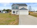Inviting two-story home with gray siding, an attached two-car garage, and a spacious front yard at 41 Aldermann (Lot 2) Ct, Dunn, NC 28334
