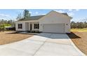 New home showcasing concrete driveway, white siding, black shutters, and attached two car garage at 4955 Ray Rd, Spring Lake, NC 28390
